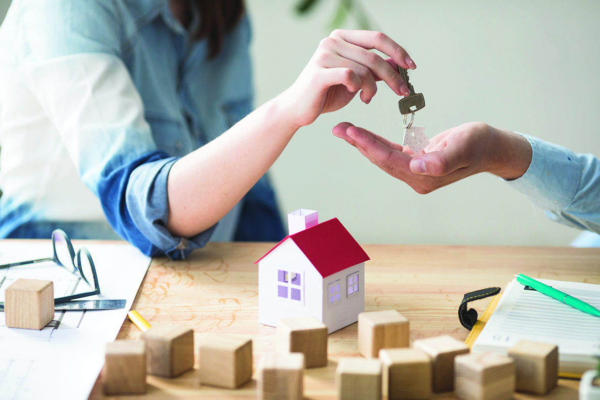 close-up-woman-s-hand-giving-house-key-man-wooden-table.jpg